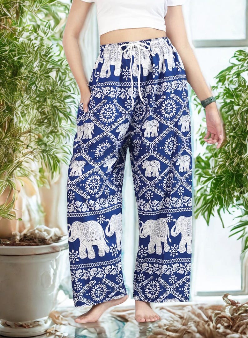 May include: Blue and white patterned pants with an elephant motif. The pants have a drawstring waist and a wide-leg design. The elephant pattern is repeated throughout the pants, creating a cohesive and eye-catching look. The pants are made of a lightweight fabric.