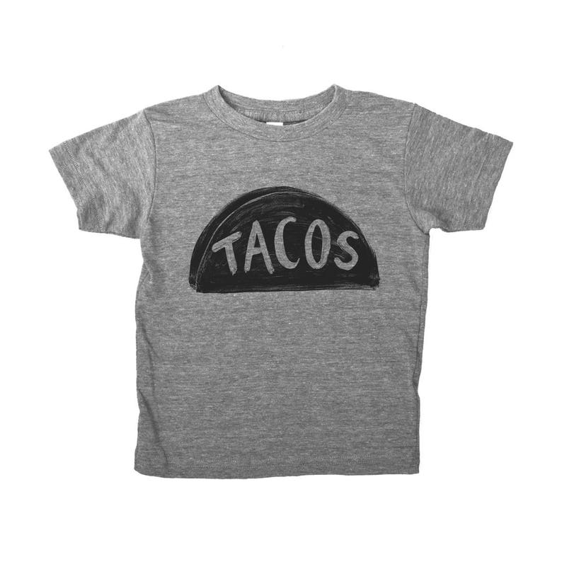 May include: A grey t-shirt with a black graphic of a taco with the word "TACOS" written on it.