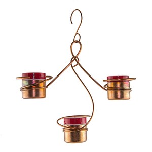 May include: A copper wire hanging feeder with three red and clear glass hummingbird feeders. The feeder has a hook for hanging.