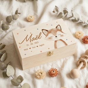 Peut inclure: Un coffret souvenir en bois clair avec une illustration de renard et le nom "Maël". La boîte comprend la date 23.09.2025, l'heure 19h58, la taille 51cm et le poids 3kg600. La boîte est décorée de points colorés et d'un fermoir doré.
