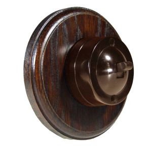 May include: A brown wooden wall plate with a dark brown Bakelite light switch.