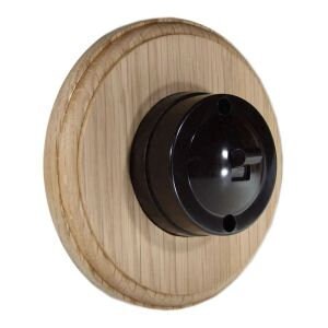 May include: Black Bakelite light switch with a wooden surround. The switch has a round, black button with two holes.