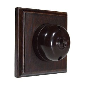 May include: A dark brown wooden light switch plate with a black bakelite toggle switch.