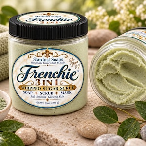 May include: A clear plastic jar of Stardust Soaps Frenchie 3 in 1 whipped sugar scrub with a black lid. The label reads Frenchie 3 in 1 Whipped Sugar Scrub, Soap, Scrub, Mask, Net Wt. 9 oz. (255 g). The scrub inside is a pale green, textured paste.