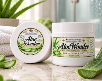 Może przedstawiać: Dwa białe plastikowe słoiki z bezzapachowym kremem do pielęgnacji skóry Aloe Wonder marki Stardust Soaps do twarzy, dłoni i ciała. Etykiety zawierają zielone ilustracje aloesu oraz napis Net Wt. 4 oz (113 g). Jeden słoik jest widoczny z góry.