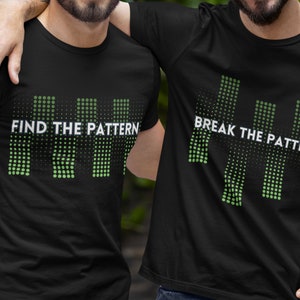 Puede incluir: Dos camisetas negras con un diseño gráfico de puntos verdes y blancos que forman la forma de barras verticales. El texto "FIND THE PATTERN" está en una camiseta y "BREAK THE PATTERN" en la otra.