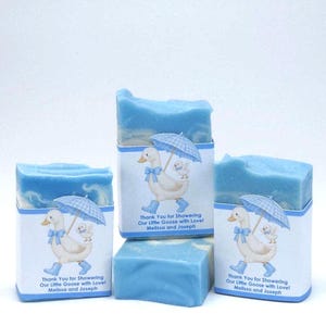 Three blue silly goose baby shower soap favors displayed unwrapped, showing handmade blue soap bars with matching goose design labels on a clean white background