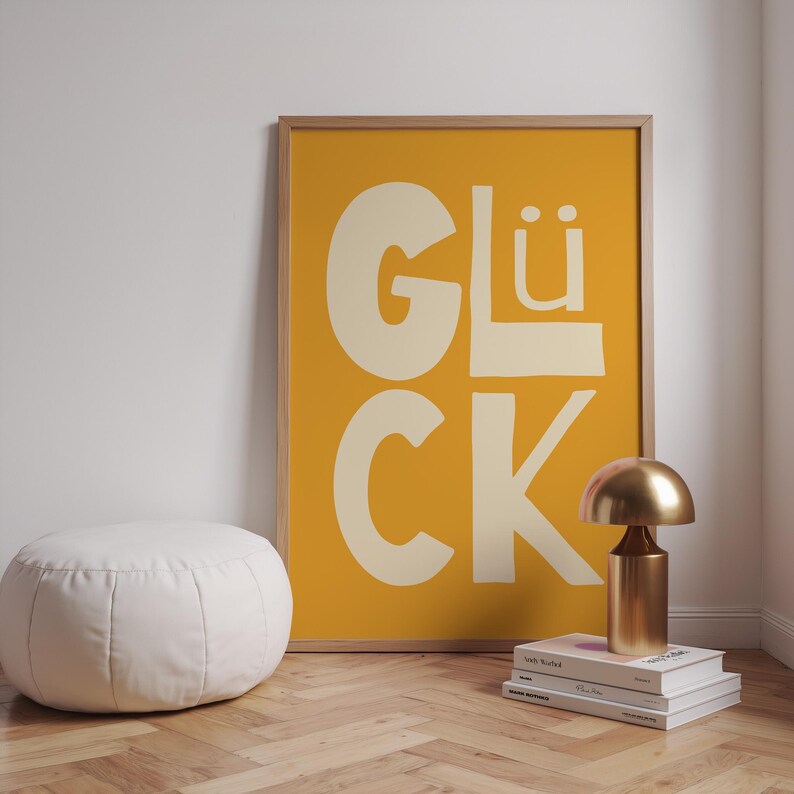 Gelbes Typografie Poster mit dem Wort „Glück“. Modernes Wandbild für Wohnzimmer, Küche oder Büro. Strahlt Motivation, Energie und Positivität aus – perfekt als Geschenk oder Deko für Zuhause und Familie.