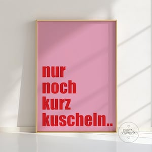 Op de afbeelding: Een ingelijste roze kunstprint met de Duitse tekst "nur noch kurz kuscheln.." in het rood. De print heeft een gouden lijst en een witte achtergrond. Een digitaal download-pictogram staat rechtsonder.