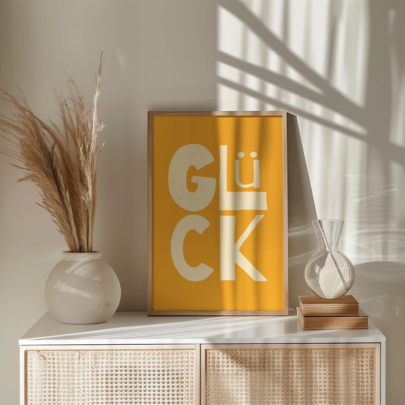 Gelbes Typografie Poster mit dem Wort „Glück“. Modernes glücklich Wandbild für Wohnzimmer, Küche oder Büro. Strahlt Motivation, Energie und Positivität aus – perfekt als Geschenk oder Deko für Zuhause und Familie.
