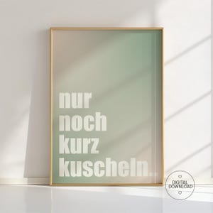 Op de afbeelding: Een ingelijste kunstdruk met een gradiëntachtergrond van zachte roze en groene tinten. De witte tekst luidt "nur noch kurz kuscheln...". De lijst is goudkleurig en de print is gemarkeerd met "DIGITALE DOWNLOAD" in een kleine cirkel.