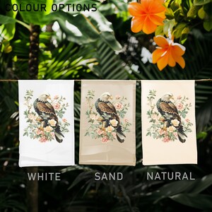 May include: Three garden flags with a brown eagle perched on a branch with pink flowers. The flags are displayed on a white, sand, and natural background. The text "COLOUR OPTIONS" is at the top of the image. The flags are labeled "WHITE", "SAND", and "NATURAL".