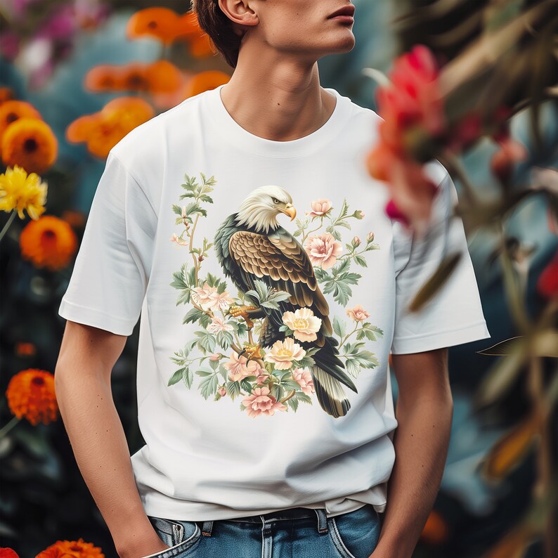 May include: White t-shirt with a graphic print of a bald eagle perched on a branch with pink flowers.