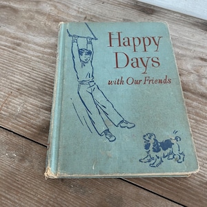 Puede incluir: Libro antiguo titulado "Happy Days with Our Friends". La portada es de color verde azulado descolorido con ilustraciones de un niño en un columpio y un perro. El libro muestra signos de desgaste.