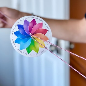 May include: A colorful, circular, paper spinner with a flower design and the text "THEY WERE ONE. THE CHILDREN OF CHRIST. AND HEIRS TO THE KINGDOM OF GOD - 4 NEPHI 117 - BUT"
