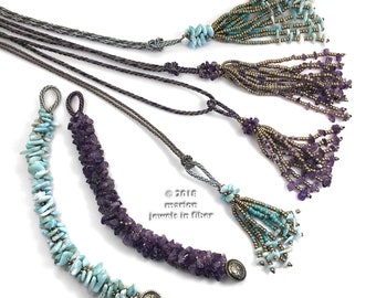 May include: Three strands of cord with tassels made of amethyst and turquoise stones. The tassels are attached to the cords with knots. The cords are gray and brown. © 2018 marion jewels in fiber