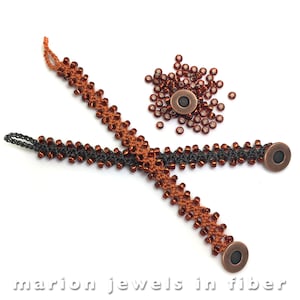 以下が含まれることがあります： 銅製のマグネット留め具が付いたビーズブレスレット2本。1本は黒と茶色、もう1本は茶色。背景には茶色のビーズの山がある。