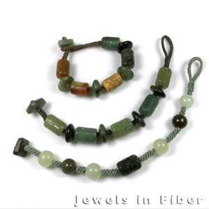 Pode incluir: Três colares de contas de jade com contas verdes, marrons e brancas. Os colares são feitos de jade e têm um design simples. Os colares são amarrados com um cordão marrom.