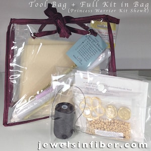 May include: A clear plastic bag with a burgundy ribbon closure contains a craft kit for jewelry making. The kit includes beads, thread, findings, and a crochet hook. The bag is labeled "Tool Bag + Full Kit in Bag (Princess Warrior Kit Shown)".