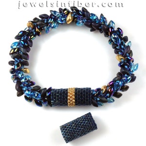 May include: A blue and gold beaded bracelet with a magnetic clasp. The bracelet is made with small, iridescent beads in shades of blue and black, and gold beads. The clasp is a cylinder with a gold band.