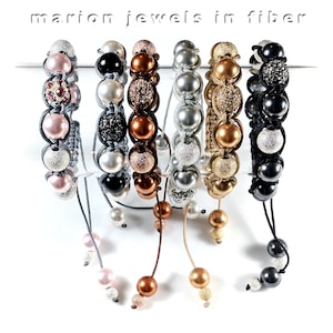 May include: Seven beaded bracelets with different colored beads and a silver, gold, black, and pink bead at the end of each bracelet. The bracelets are made with fiber and have a variety of colors including pink, silver, gold, black, and brown.