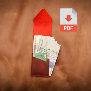 Può includere: Un portafoglio in pelle rossa dal design verticale, contenente diverse banconote e una carta di credito verde. Il portafoglio è aperto, rivelando il suo contenuto. Una forma di busta rossa è sopra il portafoglio. Un'icona PDF si trova in alto a destra.