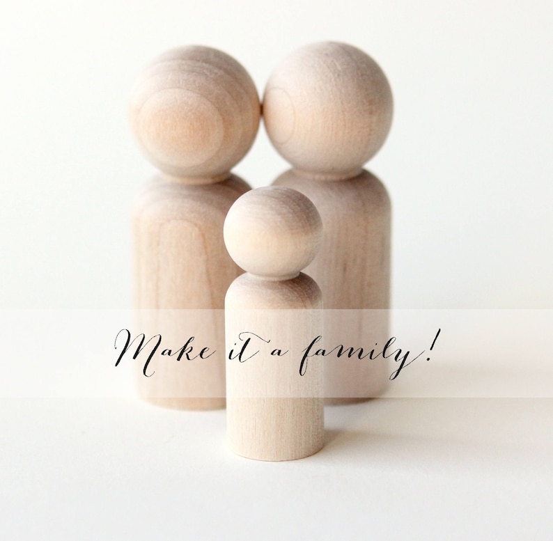 Puede incluir: Tres mu&ntilde;ecos de madera sin pintar, que representan a una familia, se alzan sobre un fondo blanco. Los mu&ntilde;ecos tienen cabezas redondeadas y cuerpos cil&iacute;ndricos. El texto "Make it a family!" est&aacute; escrito en la parte inferior.