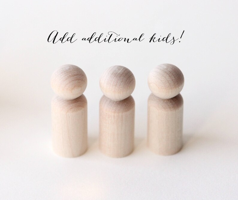 Puede incluir: Tres mu&ntilde;ecos de madera sin terminar con cabezas redondeadas. Los mu&ntilde;ecos est&aacute;n de pie sobre un fondo blanco. El texto "Add additional kids!" est&aacute; escrito en cursiva encima de los mu&ntilde;ecos.
