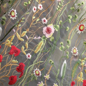 May include: White sheer fabric with embroidered flowers in shades of red, pink, yellow, and green.