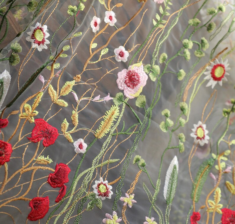 May include: White sheer fabric with embroidered flowers in shades of red, pink, yellow, and green.