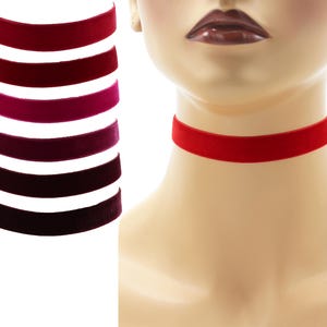 May include: A set of eight velvet chokers in various shades of red, pink, and purple. The chokers are shown on a white background.