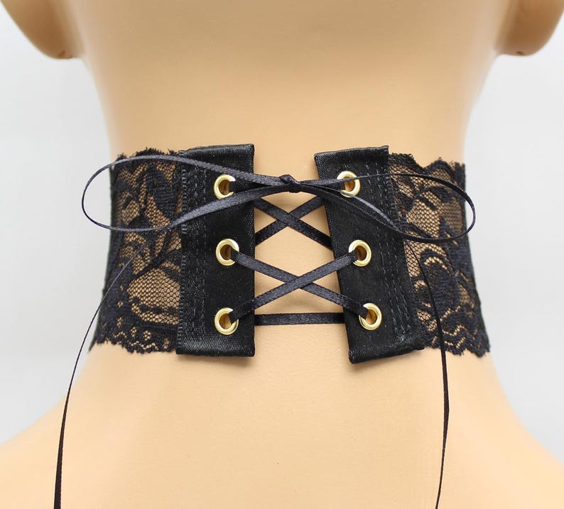 May include: Black lace choker with a satin ribbon tie and gold eyelets. The choker is adjustable and can be tied at the back of the neck.