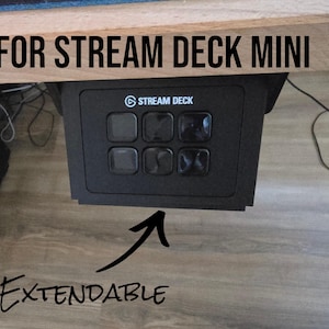 Könnte beinhalten: Schwarzes Stream Deck Mini mit sechs anpassbaren Tasten, unter einer Holzoberfläche montiert. Der Text "FOR STREAM DECK MINI" befindet sich über dem Gerät, und "EXTENDABLE" steht darunter.