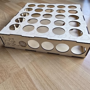 May include: A wooden organizer with multiple circular openings. The sides feature a cat and yarn design. The natural wood color gives it a simple, clean look. This item is designed for storage and organization.
