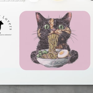 Op de afbeelding: Een roze muismat met een gedetailleerde illustratie van een kat die ramen noedels eet. De kat heeft zwart, bruin en oranje haar en groene ogen. De muismat heeft de tekst "Fur Baby Lovers" en "Because our Fur Babies deserve celebration!"