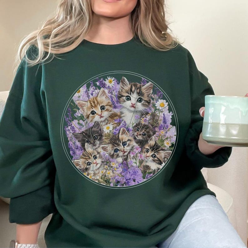 Gildan 18000 sweatshirt with vintage-style illustration of six playful kittens among lavender and wildflowers; cozy cottagecore cat lover crewneck for nostalgic and whimsical fashion.