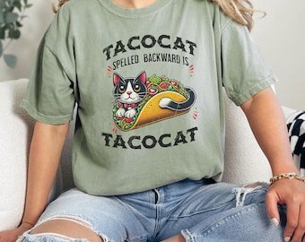 May include: A green t-shirt with a black cat in a taco. The text on the shirt reads "Tacocat spelled backward is tacocat".