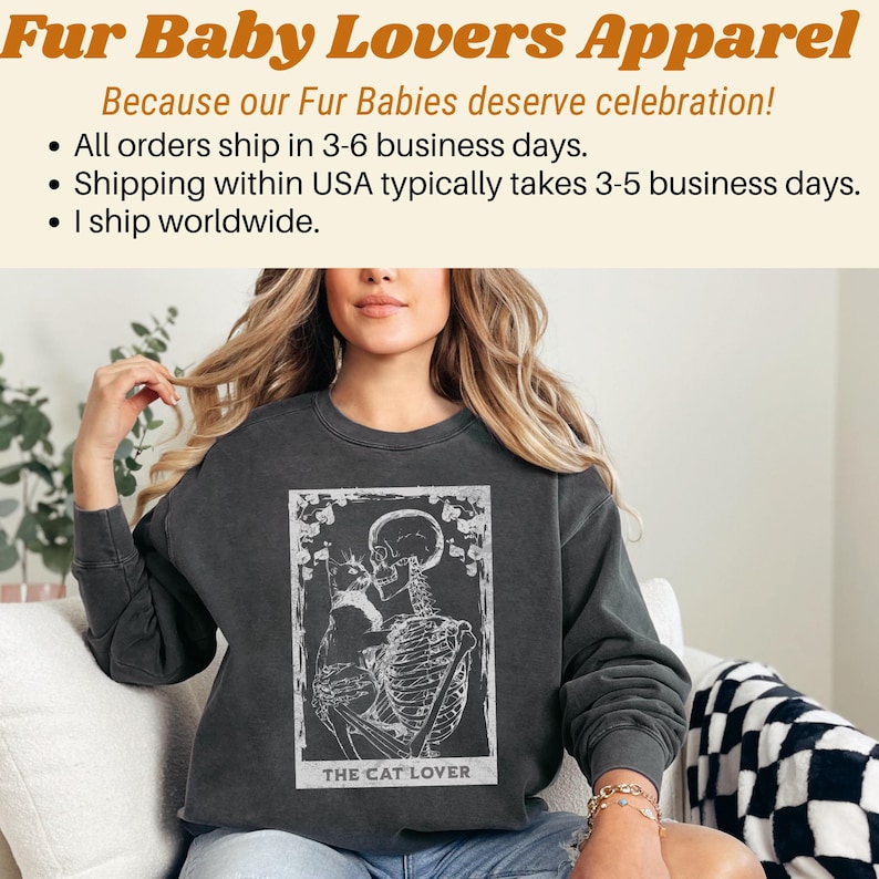 Puede incluir: Sudadera gris oscuro con un gr&aacute;fico blanco de un esqueleto abrazando a un gato, enmarcado por elementos florales. El texto "THE CAT LOVER" est&aacute; en la parte inferior. El texto superior dice "Fur Baby Lovers Apparel".