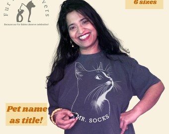 May include: A dark grey t-shirt with a white cat illustration and the text "MR. SOCKS" printed on the front. The text "Fur Baby Lovers" is printed on the top left corner of the image. The text "Because our Fur Babies deserve celebration!" is printed below the logo. The text "5 colors" and "6 sizes" is printed on the top right corner of the image. The text "Pet name as title!" is printed on the bottom left corner of the image.