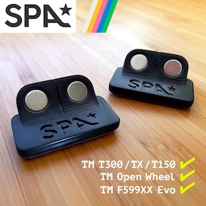 May include: Two black plastic magnetic wheel spacers with the word "SPA" and a star logo. The spacers are designed for use with the TM T300, TX, T150, Open Wheel, and F599XX Evo steering wheels.