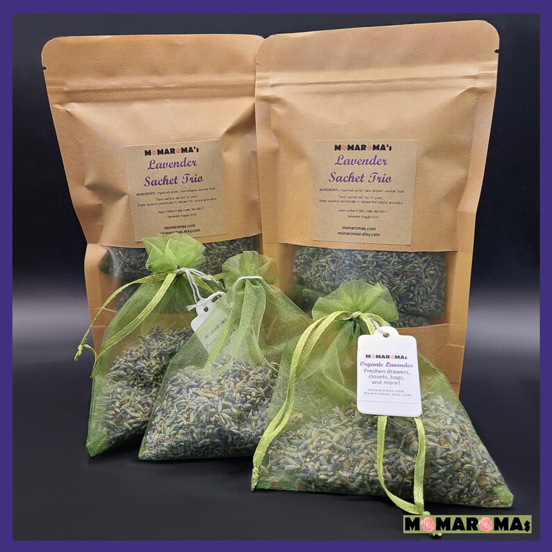 May include: Three brown paper bags with green mesh bags filled with lavender buds. The bags are labeled "Momar Ma's Lavender Sachet Trio".
