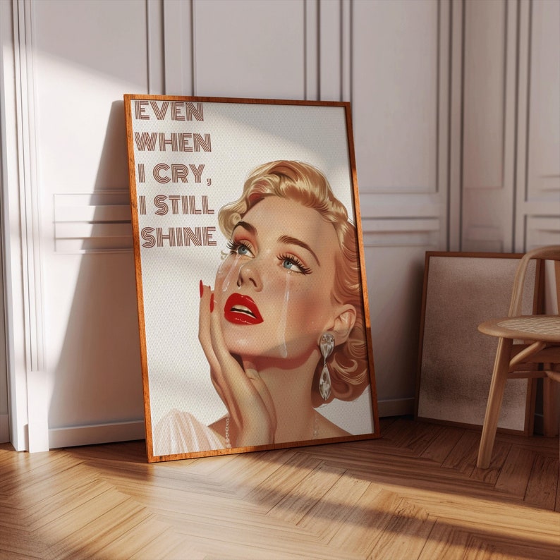 May include: A vintage-style illustration of a woman with red lipstick and tears running down her face. The text "EVEN WHEN I CRY, I STILL SHINE" is written in a retro font.