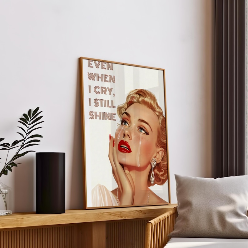 May include: A vintage-style poster featuring a woman with blonde hair and red lipstick crying. The text on the poster reads "Even when I cry, I still shine."