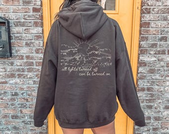 Sudadera con capucha del festival de música folklórica "Todas las luces apagadas se pueden encender"