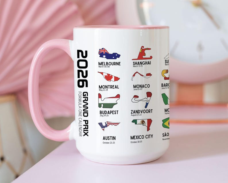 Peut inclure: Mug en c&eacute;ramique blanche avec une anse et un bord roses. Il pr&eacute;sente un calendrier du Grand Prix de Formule 1 2026 avec les trac&eacute;s et les dates des courses, dont Melbourne, Shanghai et Austin. Le mug mesure environ 10 cm de haut.