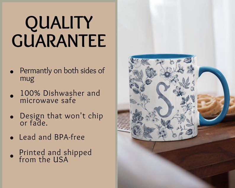 Peut inclure: Tasse en c&eacute;ramique blanche avec int&eacute;rieur et anse bleus. La tasse pr&eacute;sente un motif floral bleu et blanc, avec la lettre "S" au centre. Le texte "QUALITY GUARANTEE" est visible sur le c&ocirc;t&eacute; gauche de l'image.