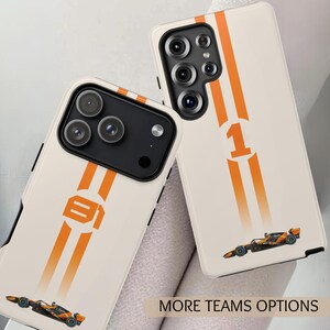 May include: Two phone cases with a cream background. Each case has orange racing stripes and a race car graphic. One case shows the number "1" and the other has the number "91". The text "MORE TEAMS OPTIONS" is visible.