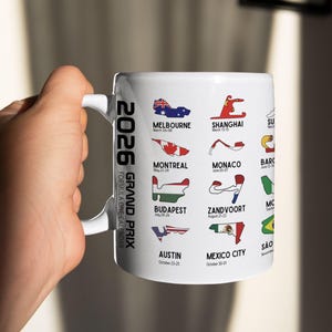 Peut inclure: Mug en c&eacute;ramique blanche avec le calendrier du Grand Prix de Formule 1 2026. Le mug affiche les trac&eacute;s des circuits de Melbourne, Montr&eacute;al, Monaco, Budapest, Zandvoort, Austin, Mexico City, etc. Le mug est tenu par une personne.