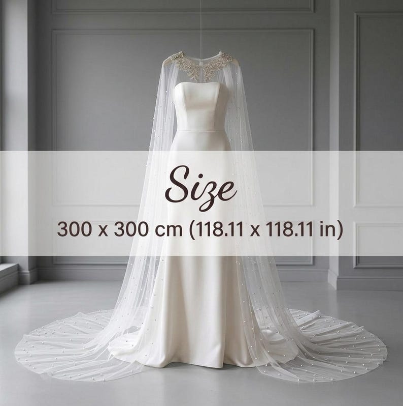 May include: A white floor-length bridal cape featuring a sheer tulle fabric adorned with scattered pearls and intricate beaded embroidery at the neckline. The cape measures 118.11 x 118.11 inches and is displayed over a simple strapless white gown.