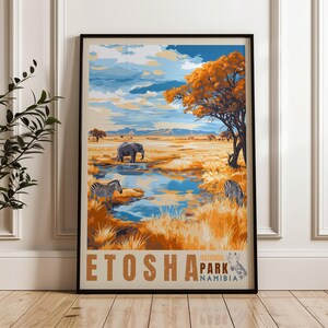 A framed poster of Etosha, Namibia, showcasing a picturesque savannah scene. It features zebras grazing, an elephant near a reflective waterhole, and a striking orange acacia tree under a dramatic, cloud-filled sky with distant mountains.